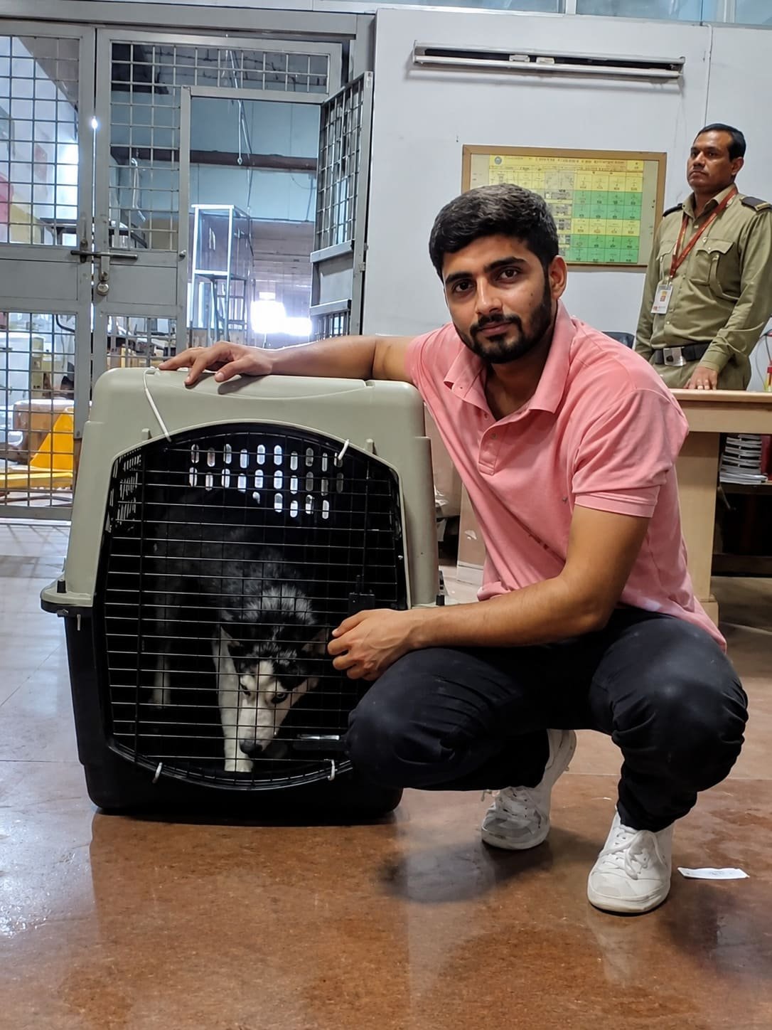 FidoJet handler beside a dog in an IATA-compliant crate at the air cargo terminal