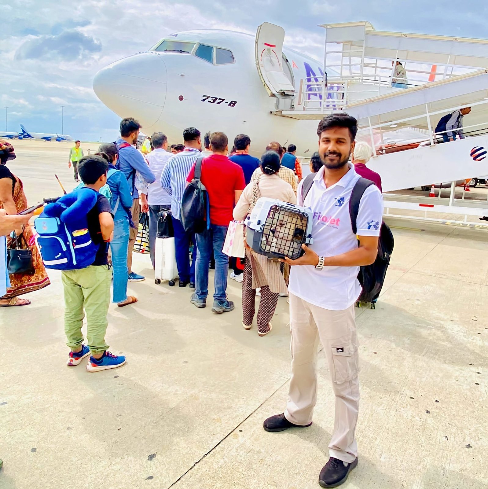 FidoJet handler carrying a pet in an IATA-compliant crate to board a flight